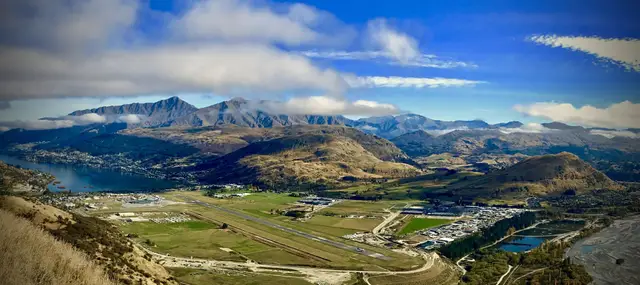 A wide view of Queenstown Airport with the Remarkables behind the runway.