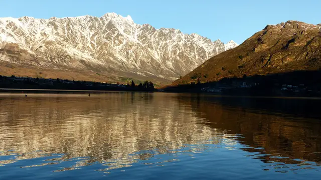 The Remarkables reflected in the still water of Lake Wakatipu.